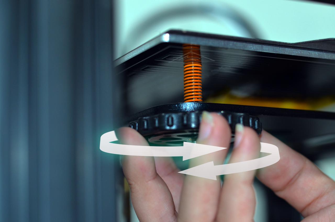 Foto demonstrando a calibração manual de uma impressora 3D através da porca de aperto