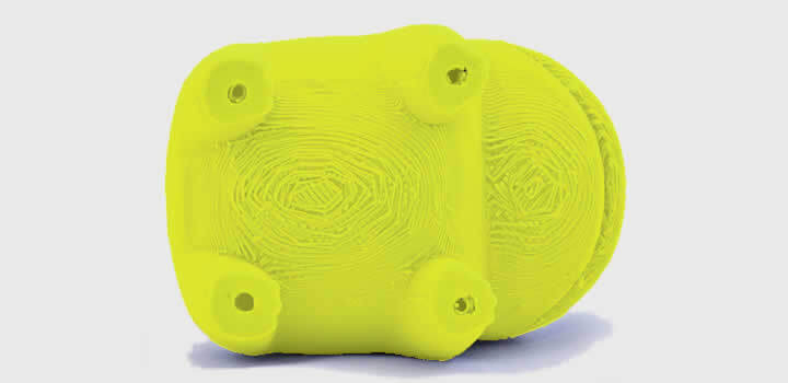 Foto de uma peça amarela impressa 3d com filamento 3d tirada da parte de baixo de uma peça que usou suporte demonstrando dificuldade com acabamento