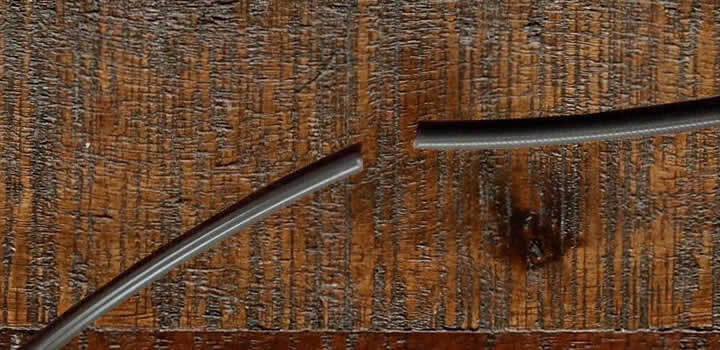 foto de dois pedaços de filamento marrom para impressora 3d quebrados em cima de uma mesa de madeira